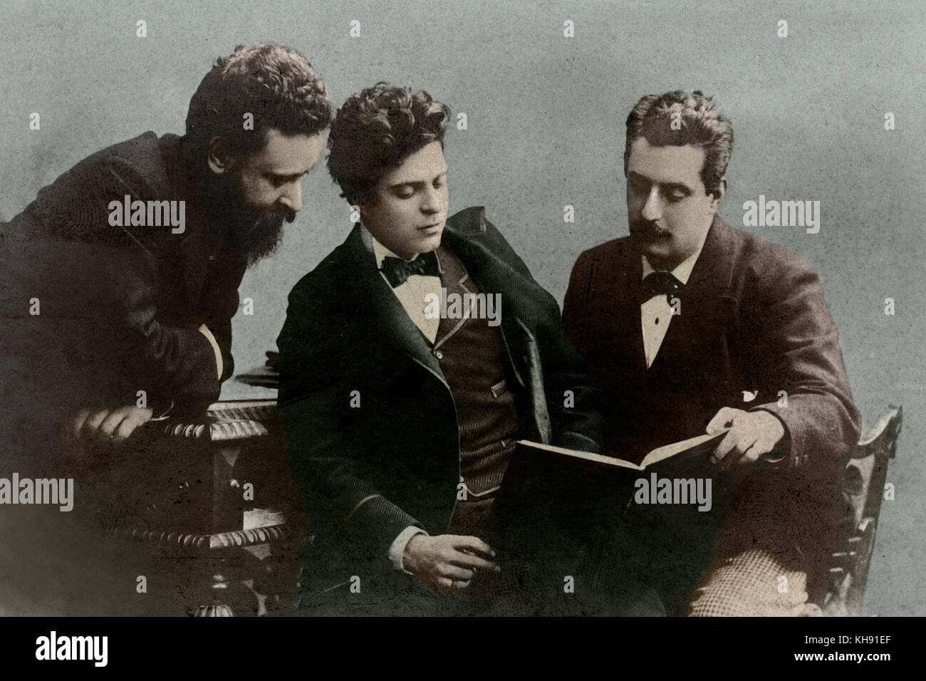 Giacomo Puccini, Pietro Mascagni & Alberto Franchetti. The three Italian opera composers looking at a score, sitting around a piano. Dates are respectively: 1858-1924, 1863-1945, 1860-1942. Stock Photo