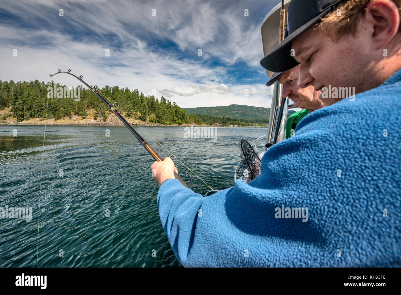 Two men, father and son, with fishing rod, on fishing boat in Johnstone