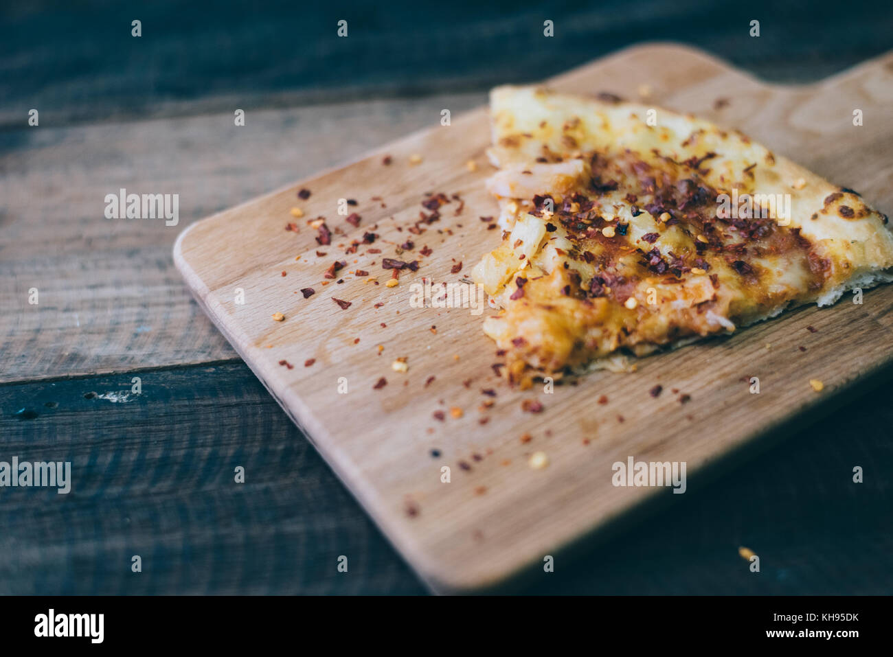 pizza slice with cheese,pineapple and chicken meat topping on a wooden board/table.famous italian food Stock Photo