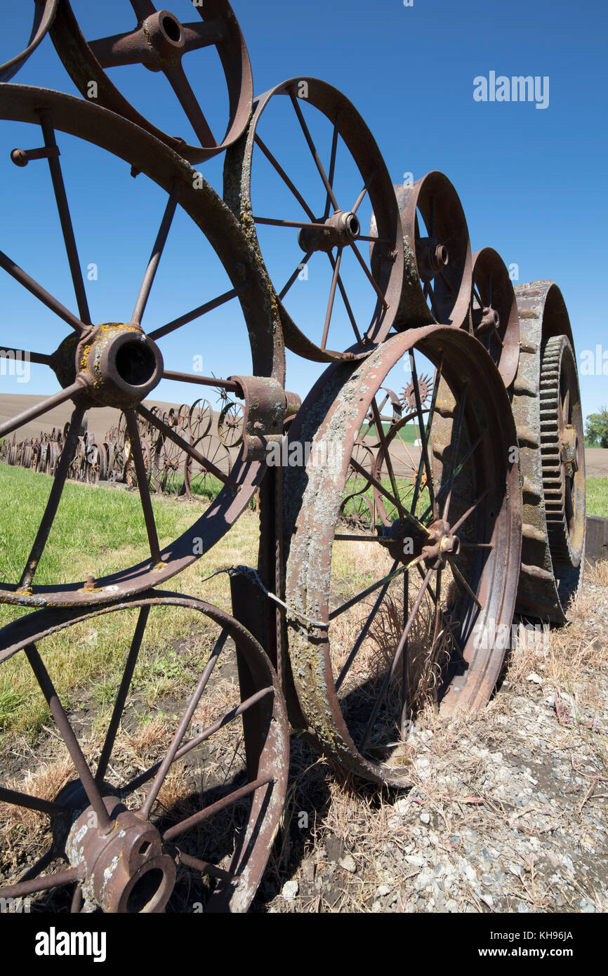 Old farm fence made of old rusty wagon & tractor wheels at the Artisans at the Dahmen Barn is on the Palouse Scenic Byway in Uniontown, Washington, Stock Photo