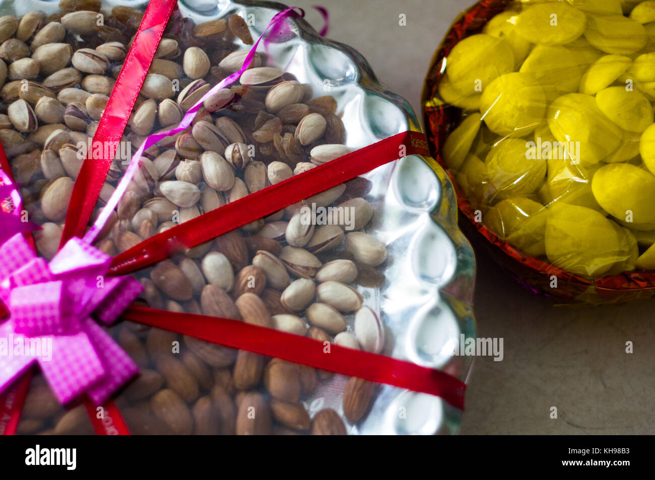 dry fruits and sweets packed in basket with cellophane and ribbons