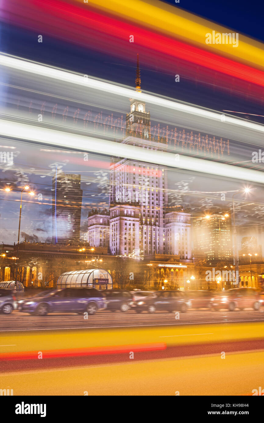 Abstract light trails in Warsaw city downtown at night in Poland, Palace of Culture and Science (Polish: Palac Kultury i Nauki) behind the lights. Stock Photo