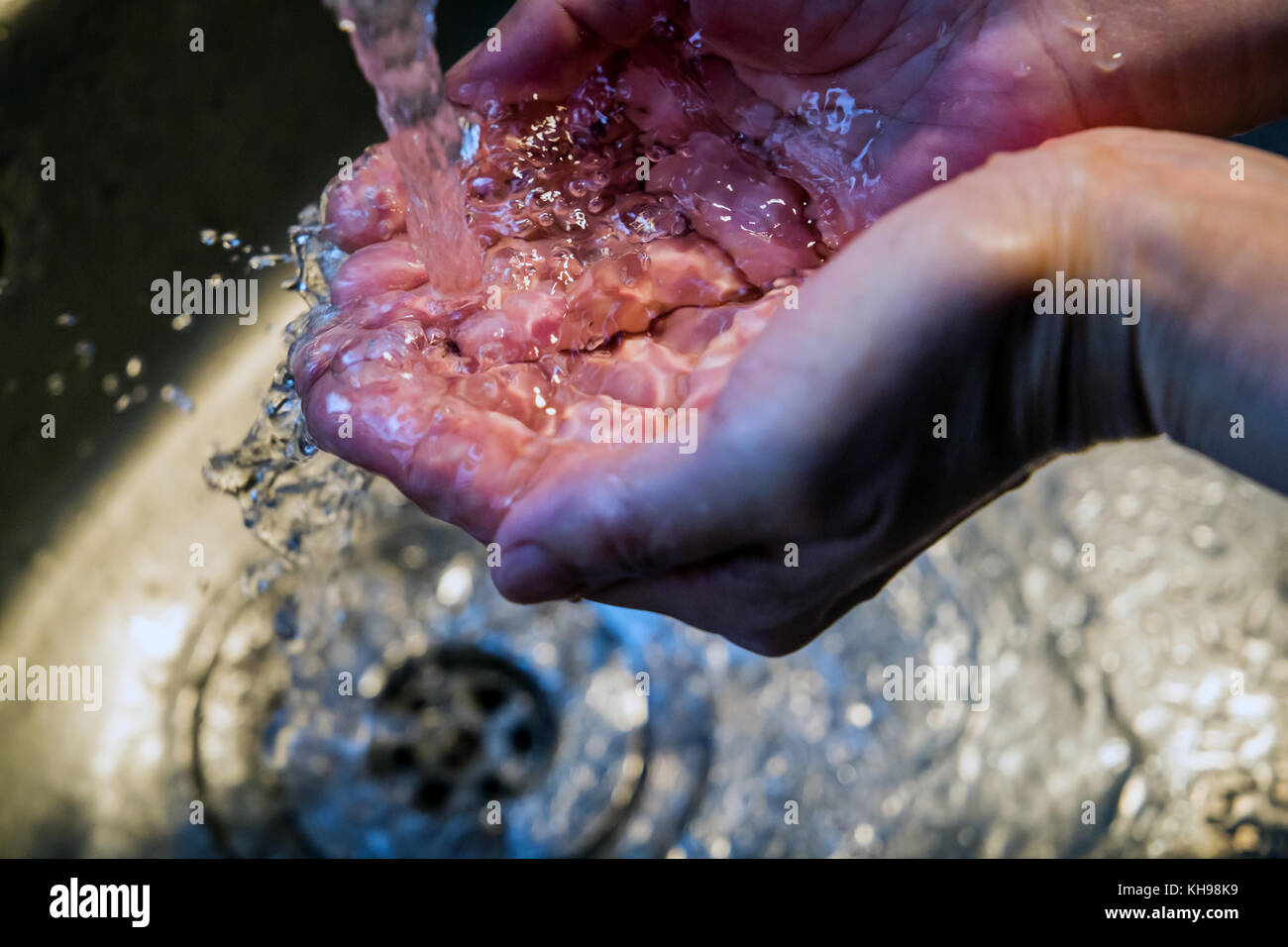 Close up of Woman washing hands in a kitchen basin (Sink) Stock Photo