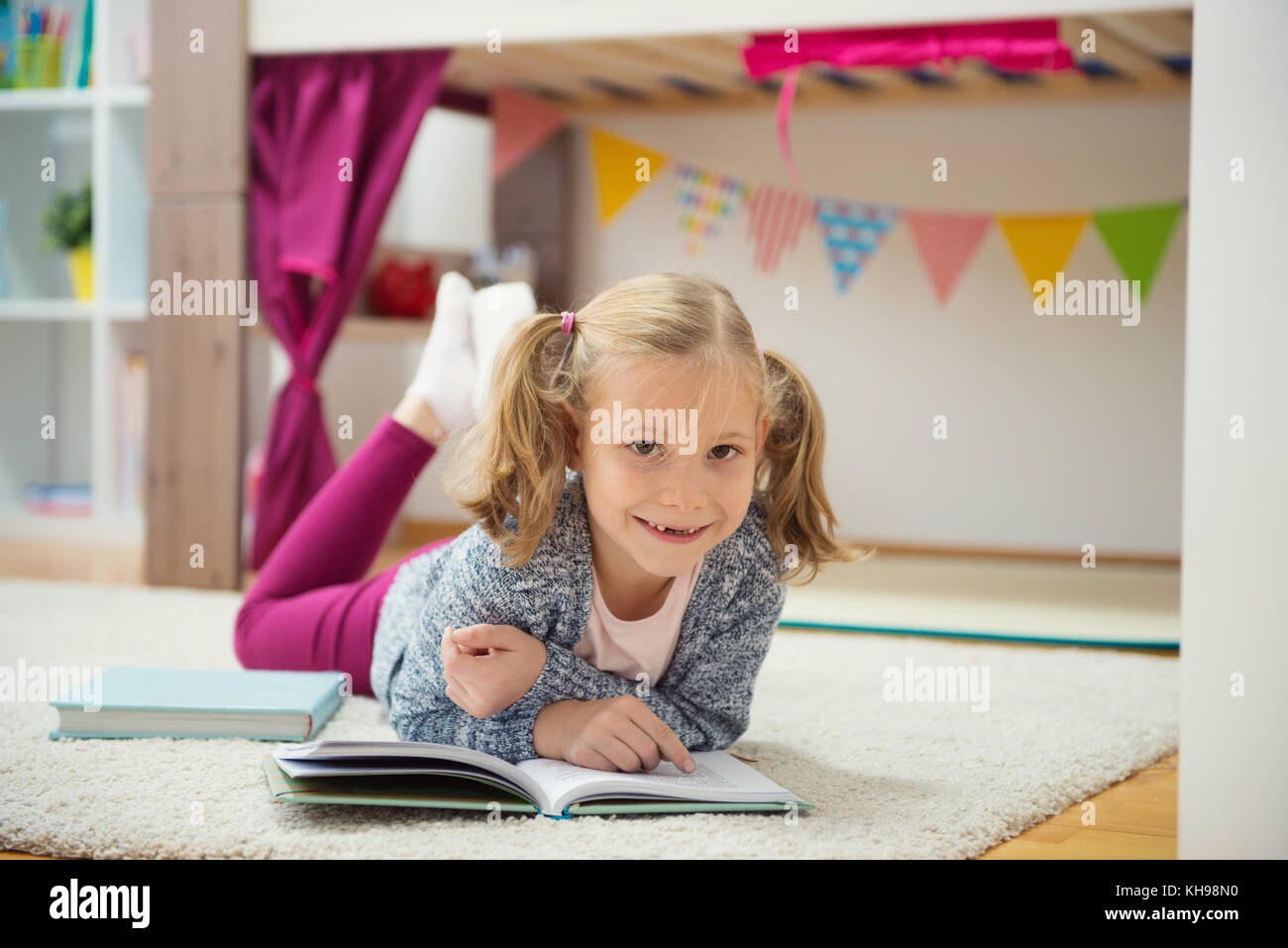 Cute little girl read book at home on floor Stock Photo - Alamy