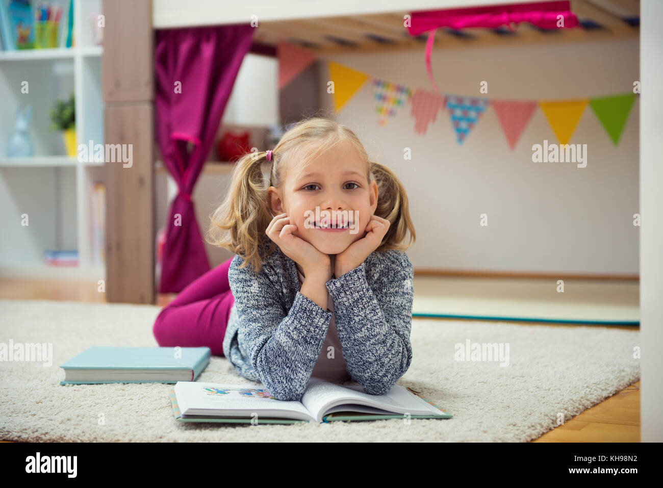 Cute little girl read book at home on floor Stock Photo - Alamy