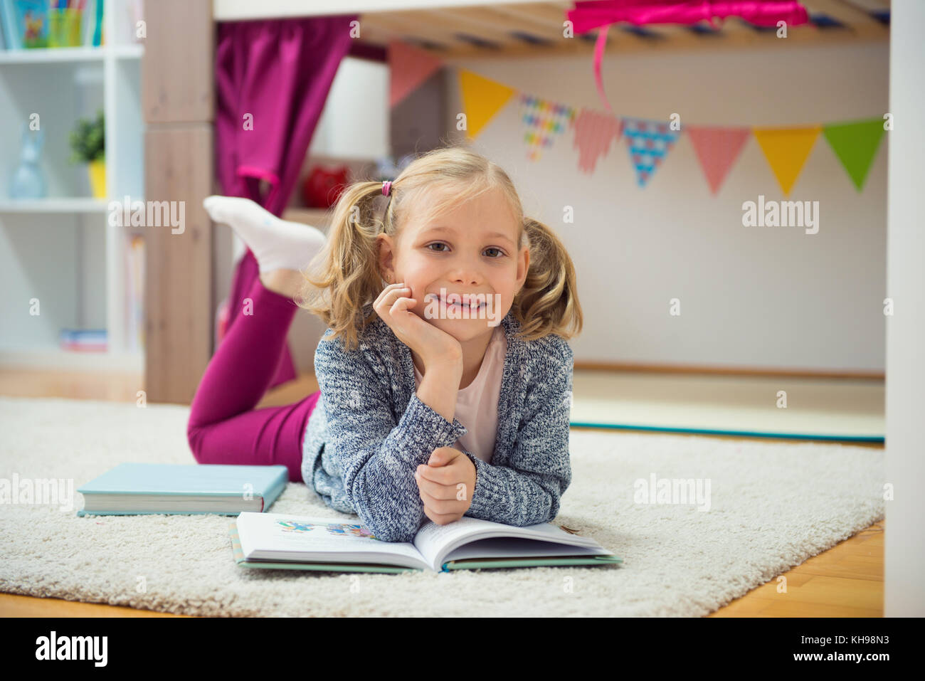 Cute little girl read book at home on floor Stock Photo - Alamy