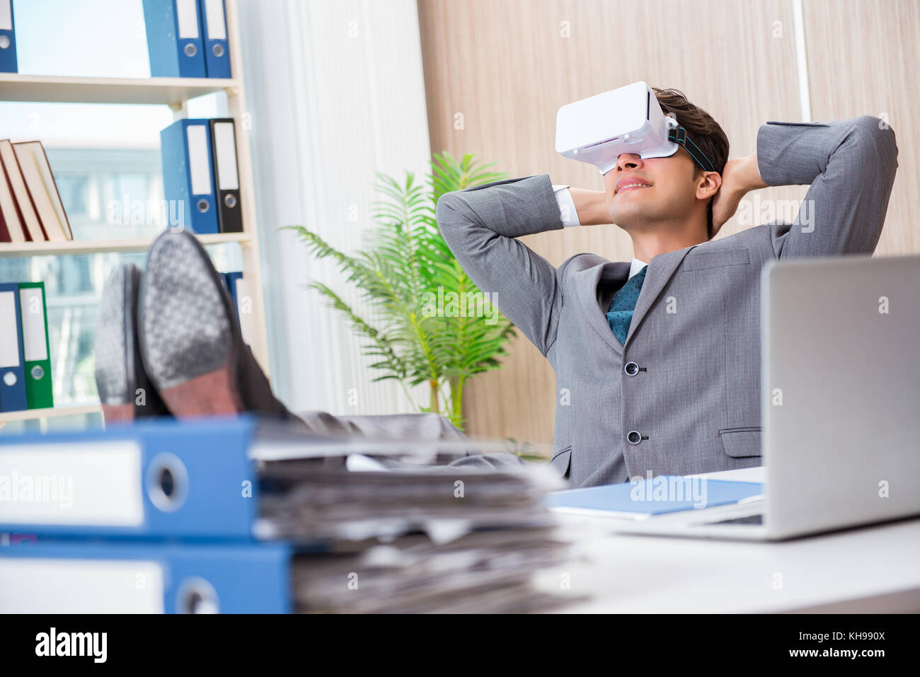 Businessman with VR virtual reality glasses in office Stock Photo - Alamy