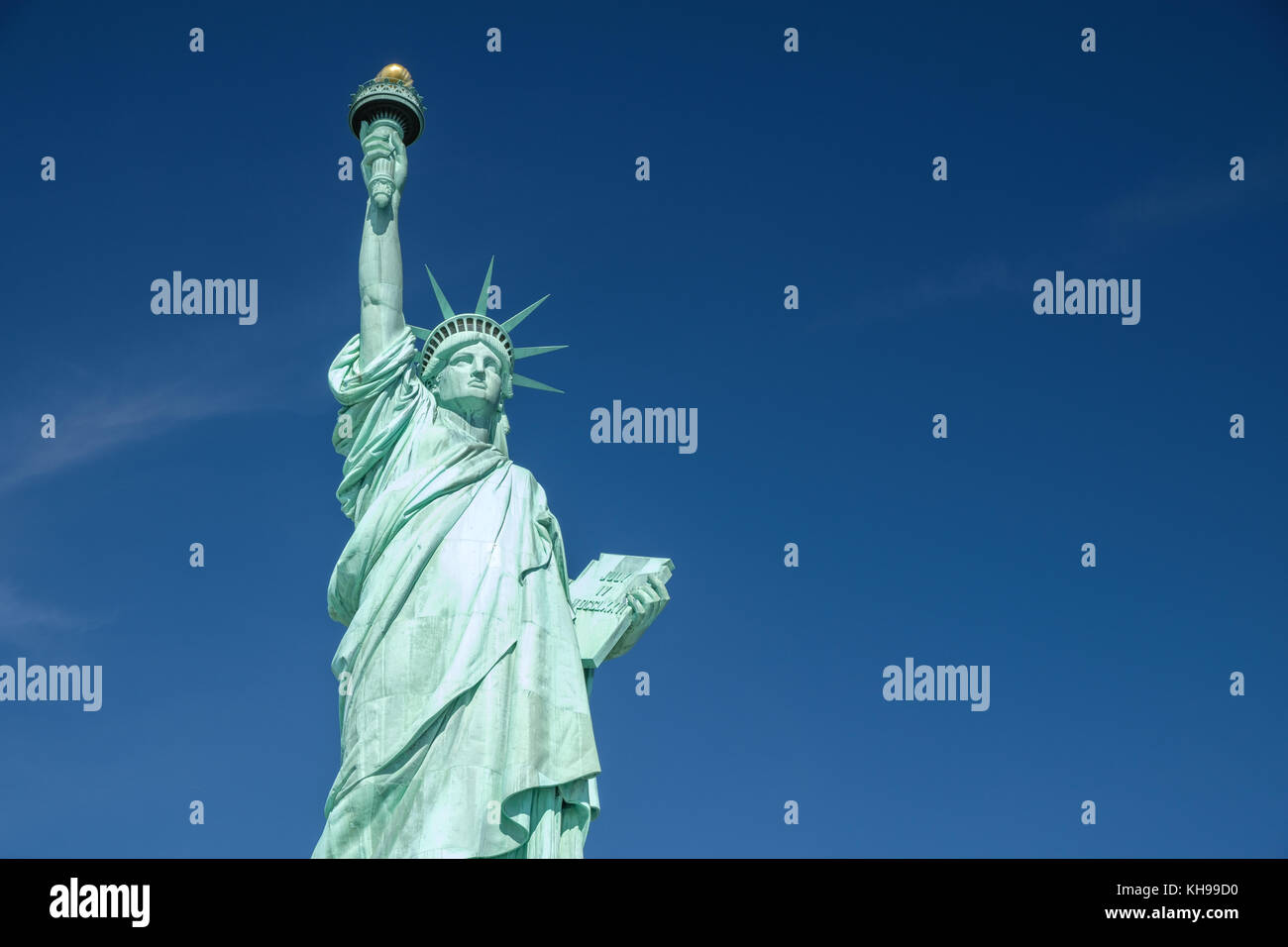Statue of Liberty close up against a blue sky, also known as Lady Liberty Stock Photo