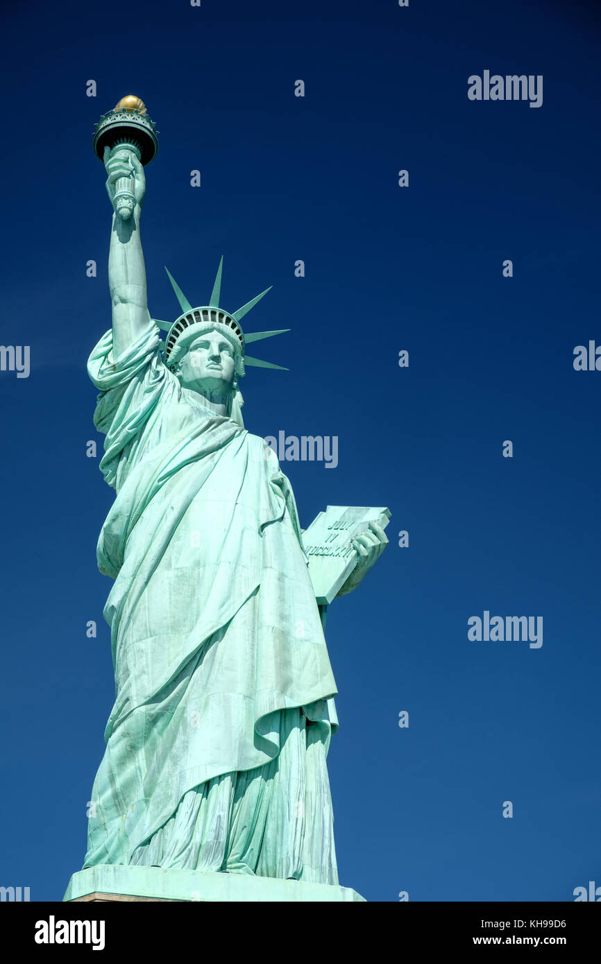 Statue of Liberty close up against a blue sky, also known as Lady Liberty Stock Photo