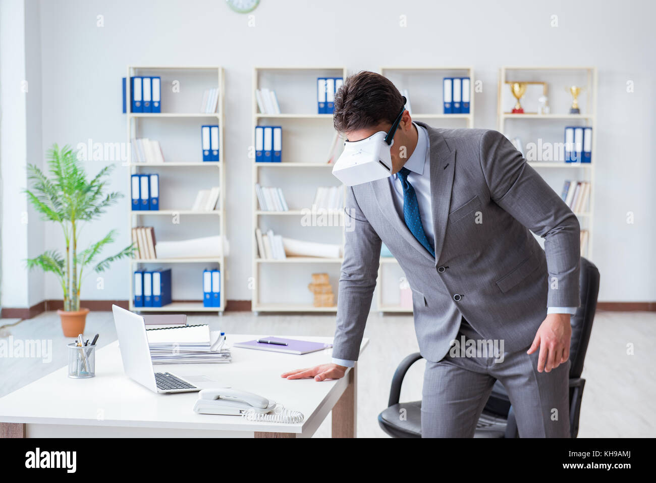 Businessman exercising in office wearing VR glasses Stock Photo - Alamy