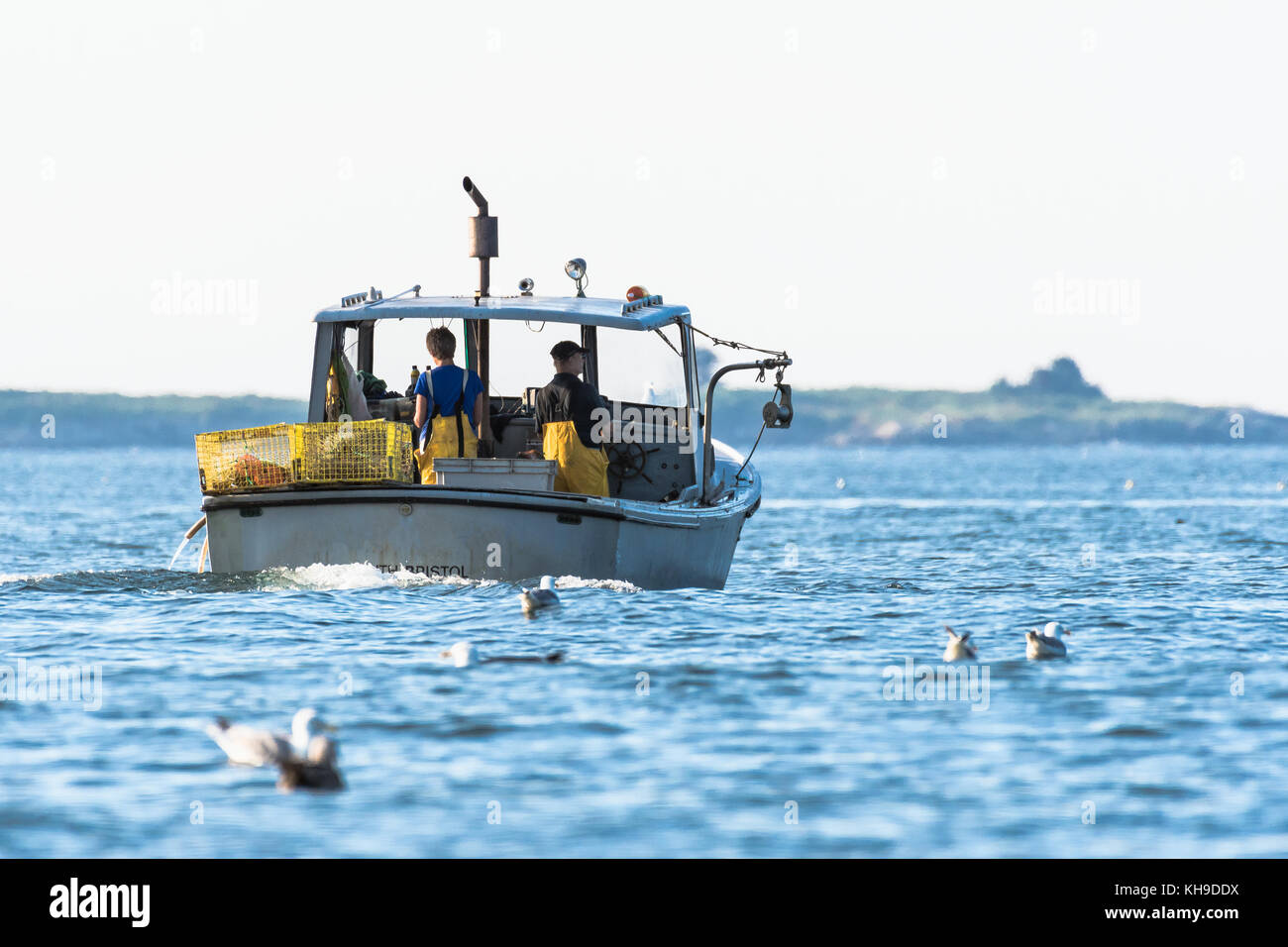 Lobster men hard at work on a beautiful morning in early autumn in South Bristol, Maine, United States Stock Photo