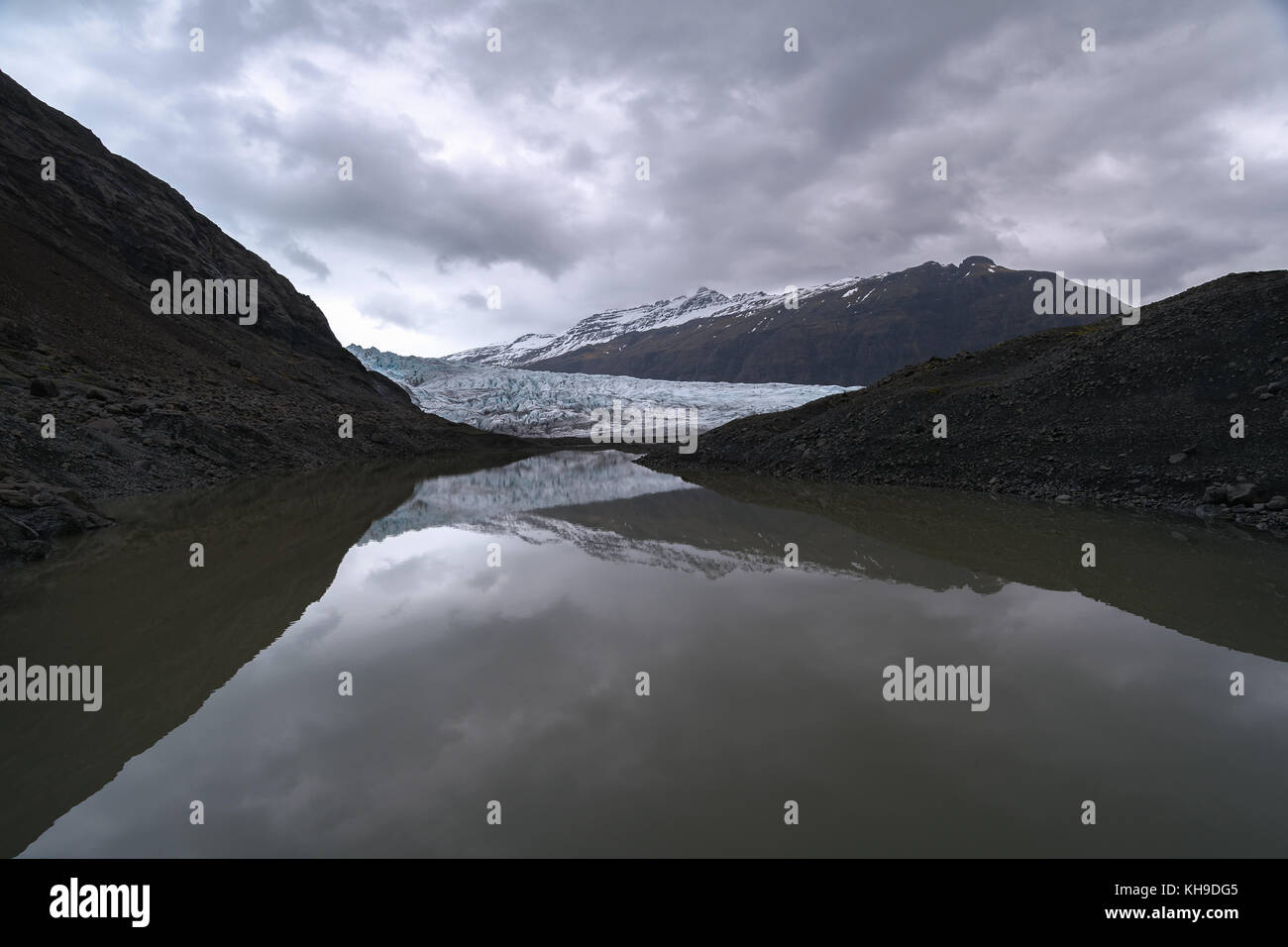 Reflection of Flaajokull glacial tongue with cinematic clouds in East Iceland Stock Photo