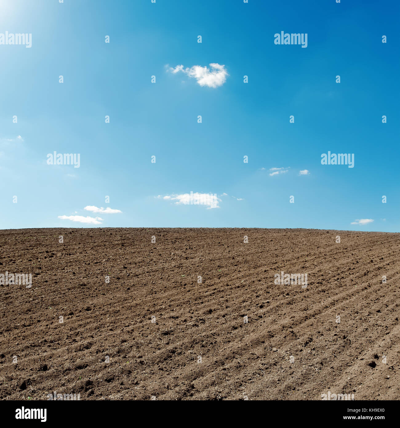 blue sky and black agriculture field Stock Photo - Alamy
