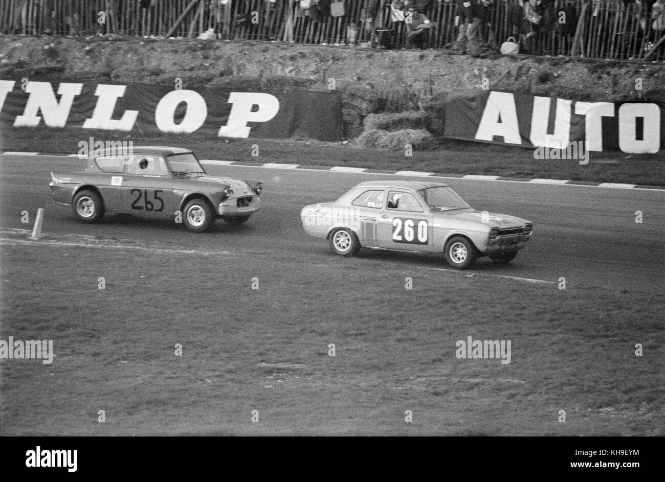 A Ford Escort Mark One, race number 260, land sponsored by Dagenham Motors, leads a Ford Anglia, race number 265, at a race at the Brands Hatch circuit in England in 1968. Stock Photo