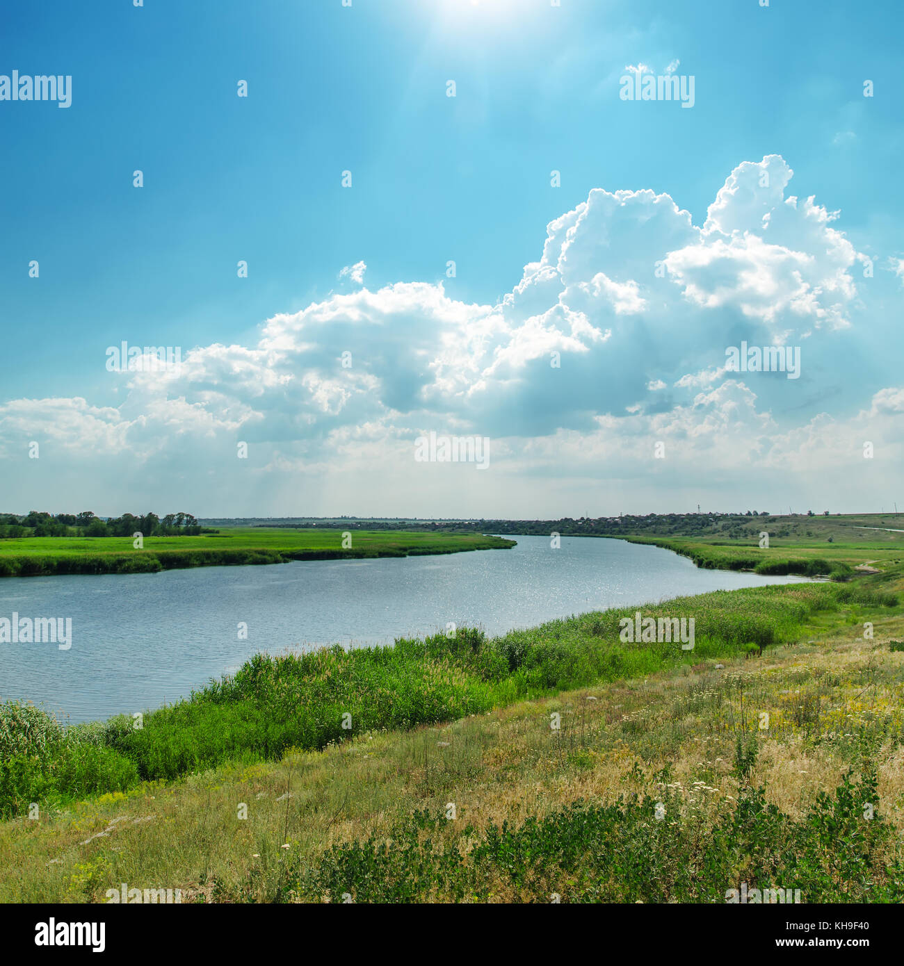 green landscape with river and cloudy sky with sun Stock Photo - Alamy