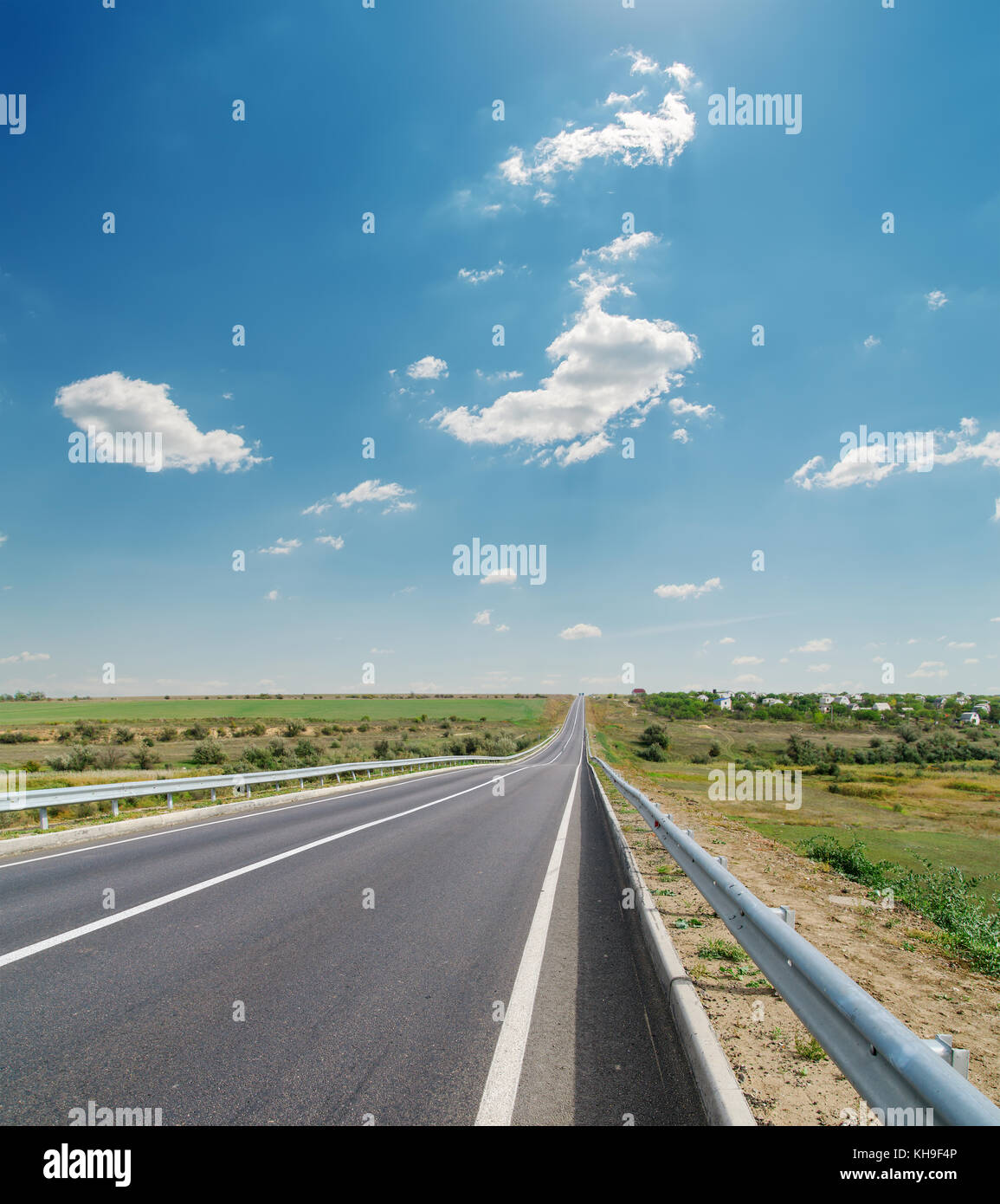 asphalt road closeup under cloudy blue sky Stock Photo - Alamy