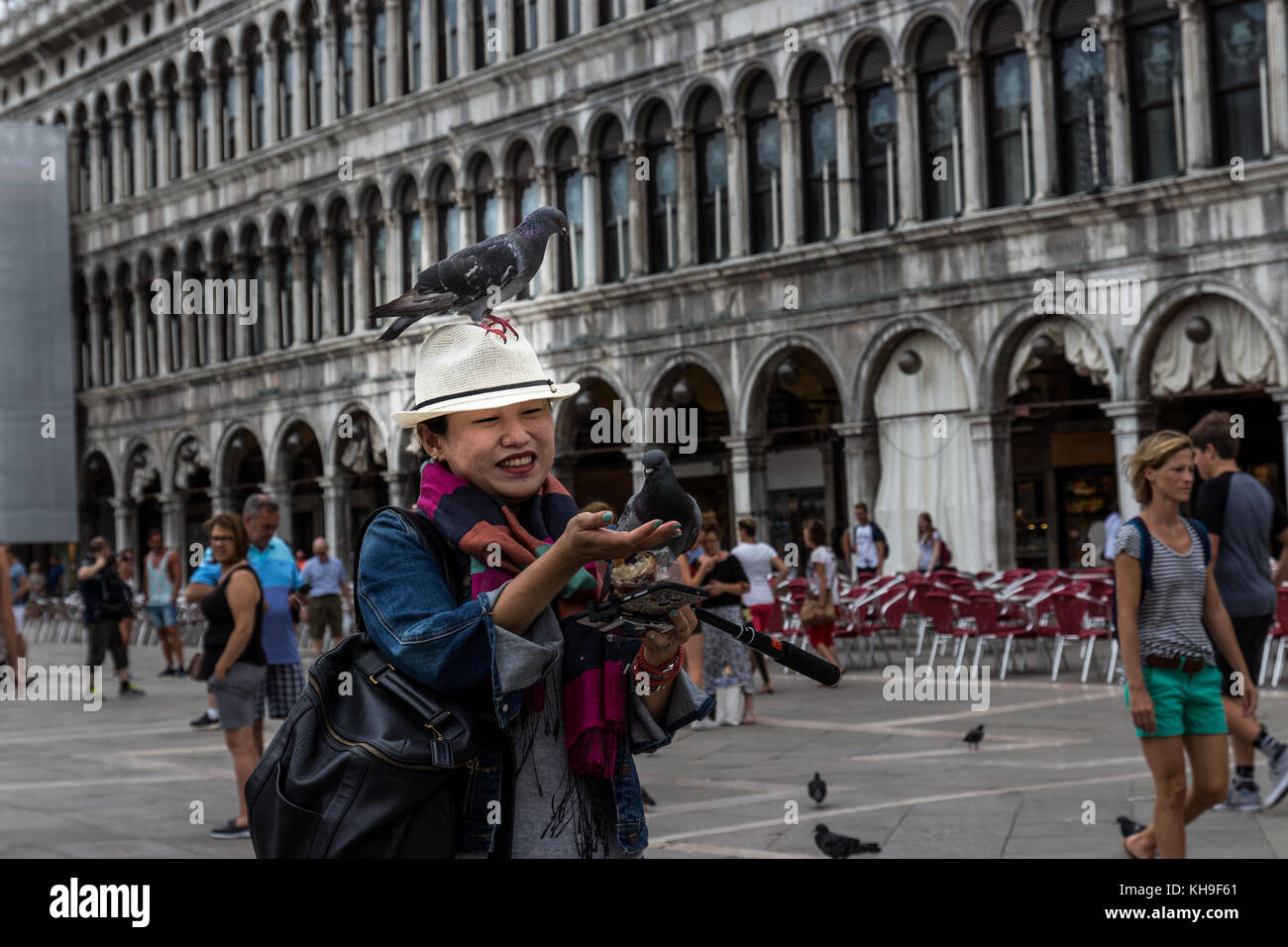 Japanse woman feed the pegions, San Marco square, Venice, Italy. Stock Photo