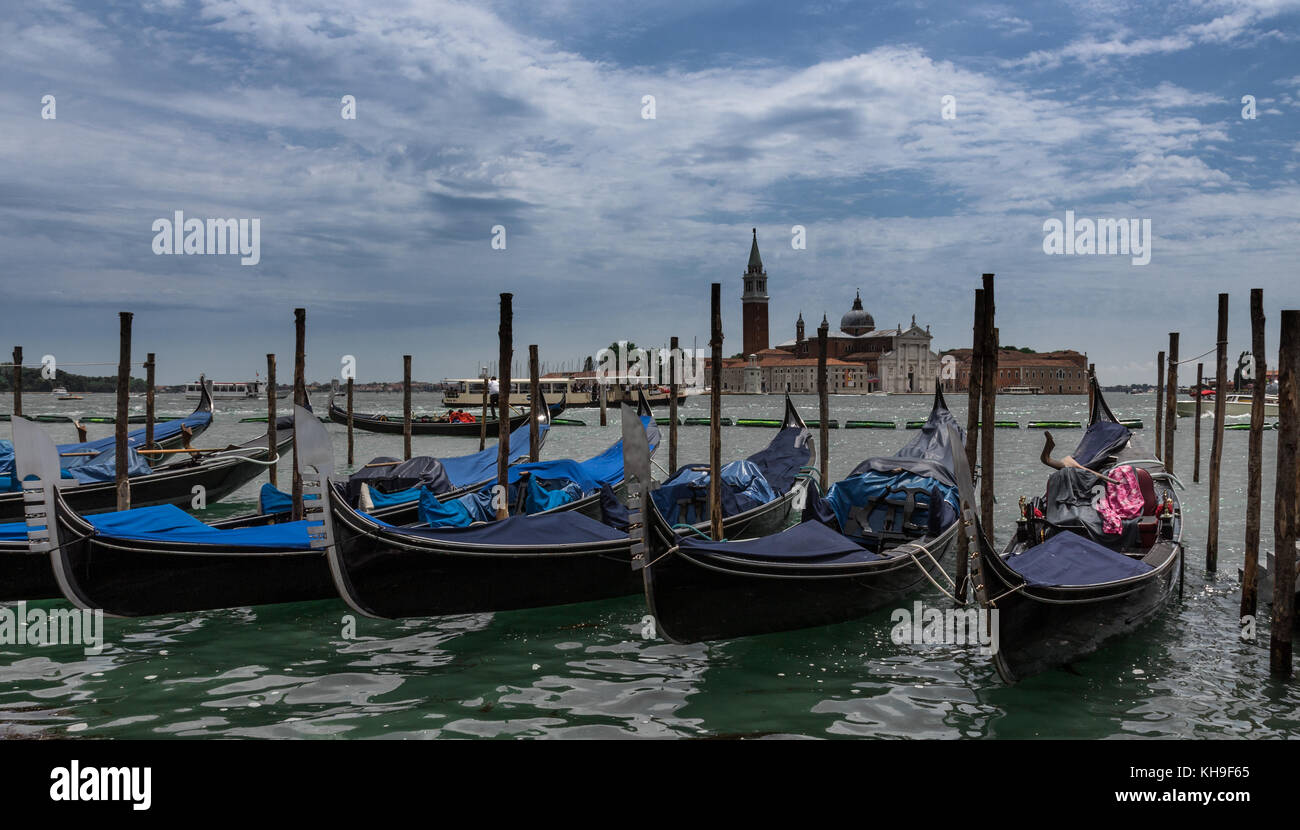 Gondolas moored by Saint Mark square with San Giorgio di Maggiore church in Venice, Italy. Stock Photo