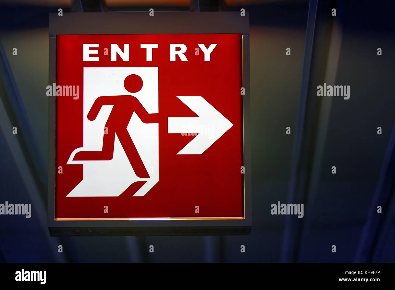 The emergency red entry sign shows the direction of entrance. The emergency entry board hangs on the ceiling of the building. Stock Photo