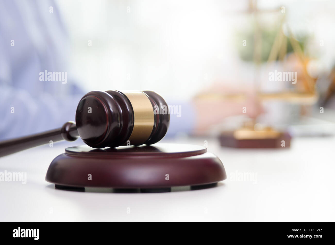 Wooden gavel, working lawyer in background. lawyer law justice judge gavel courtroom legal table concept Stock Photo