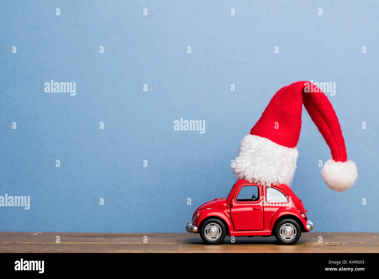 LONDON, UK - DECEMBER 15th 2016: Christmas background concept with red toy car aginst blue background Stock Photo