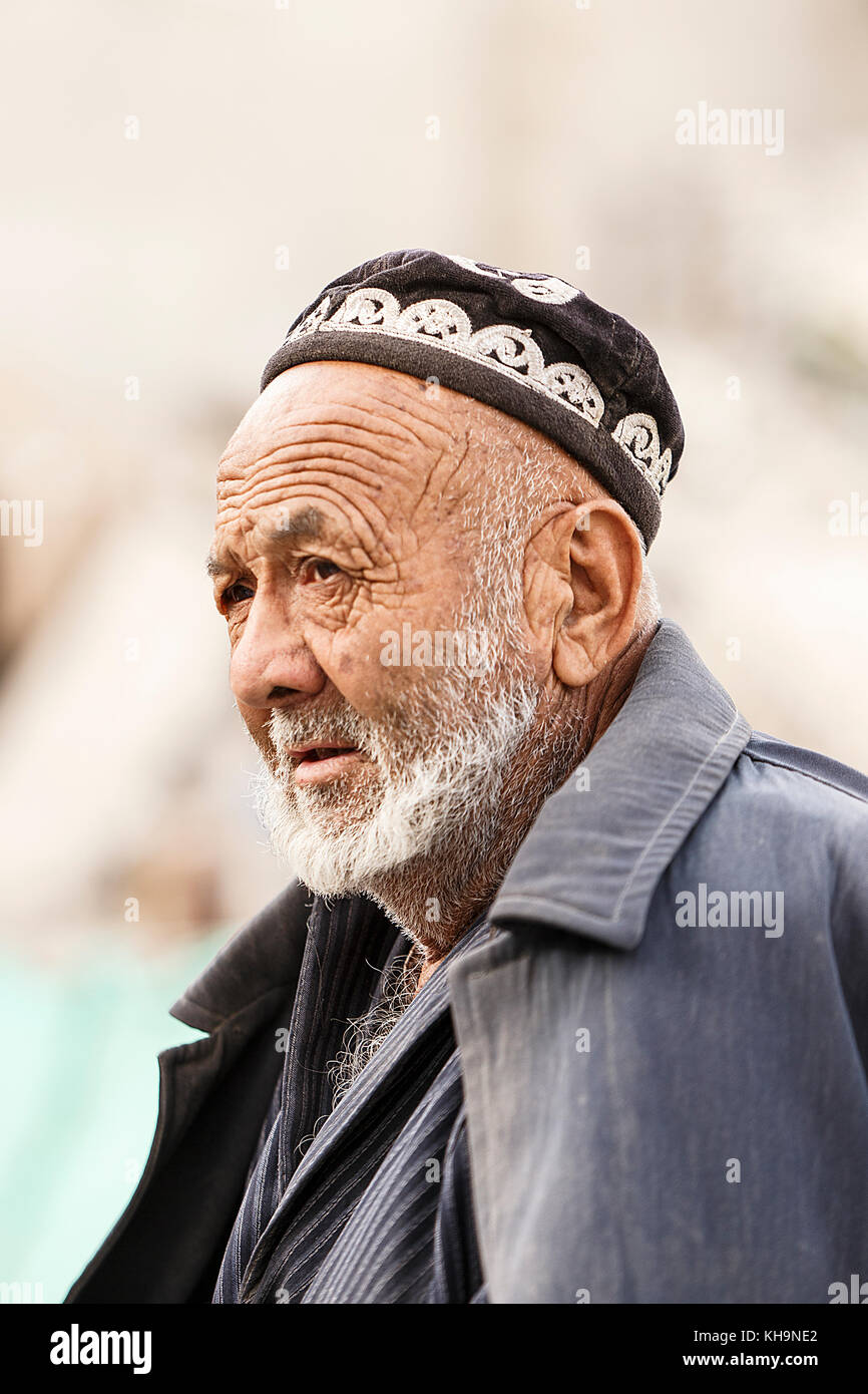 Hotan,China - October 03,2017: Uyghur elder sells his merchandise in the local market on October 03, China. Stock Photo