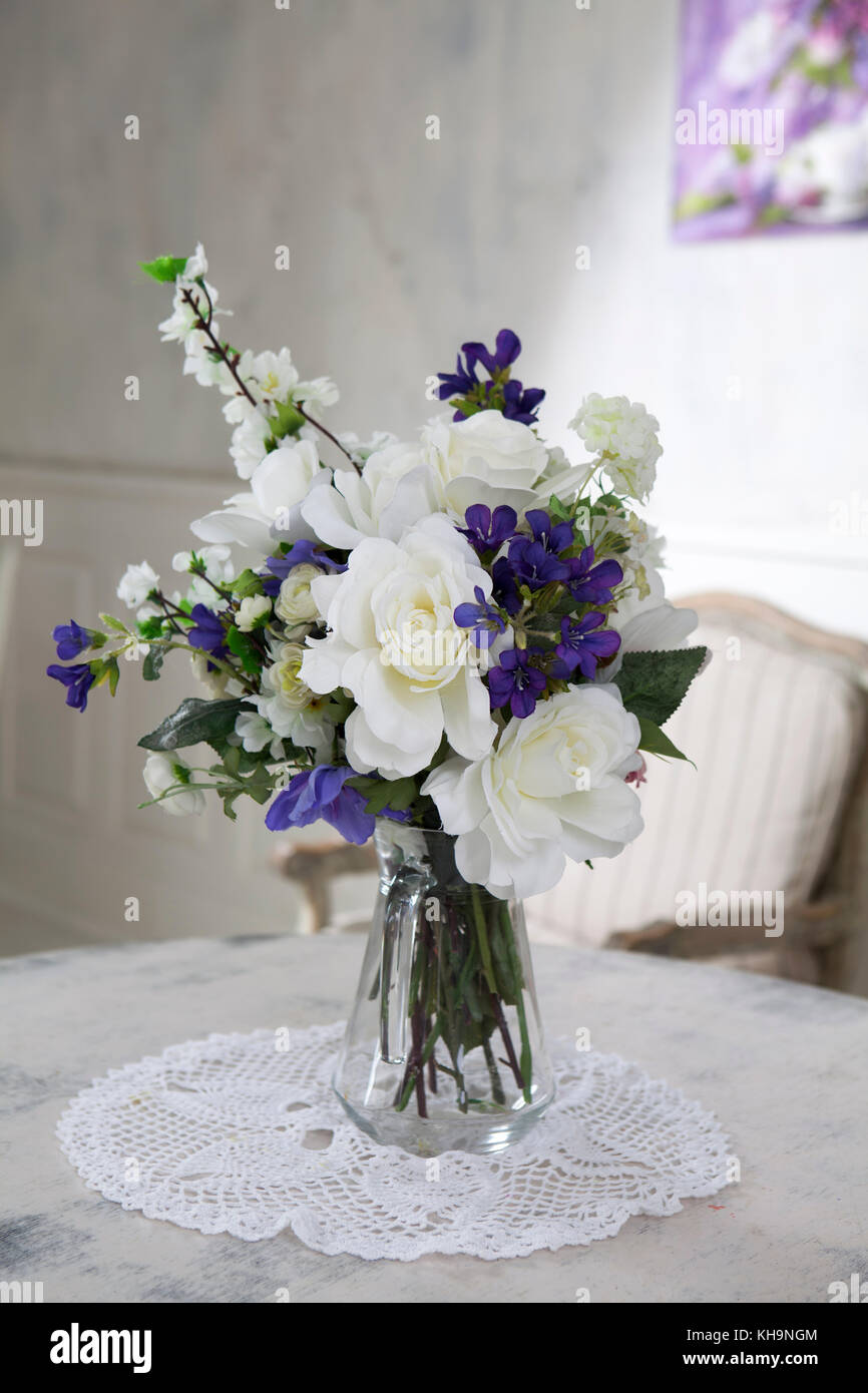 Bouquet of artificial roses, phlox and bells on a table in a vase, as an interior decoration Stock Photo