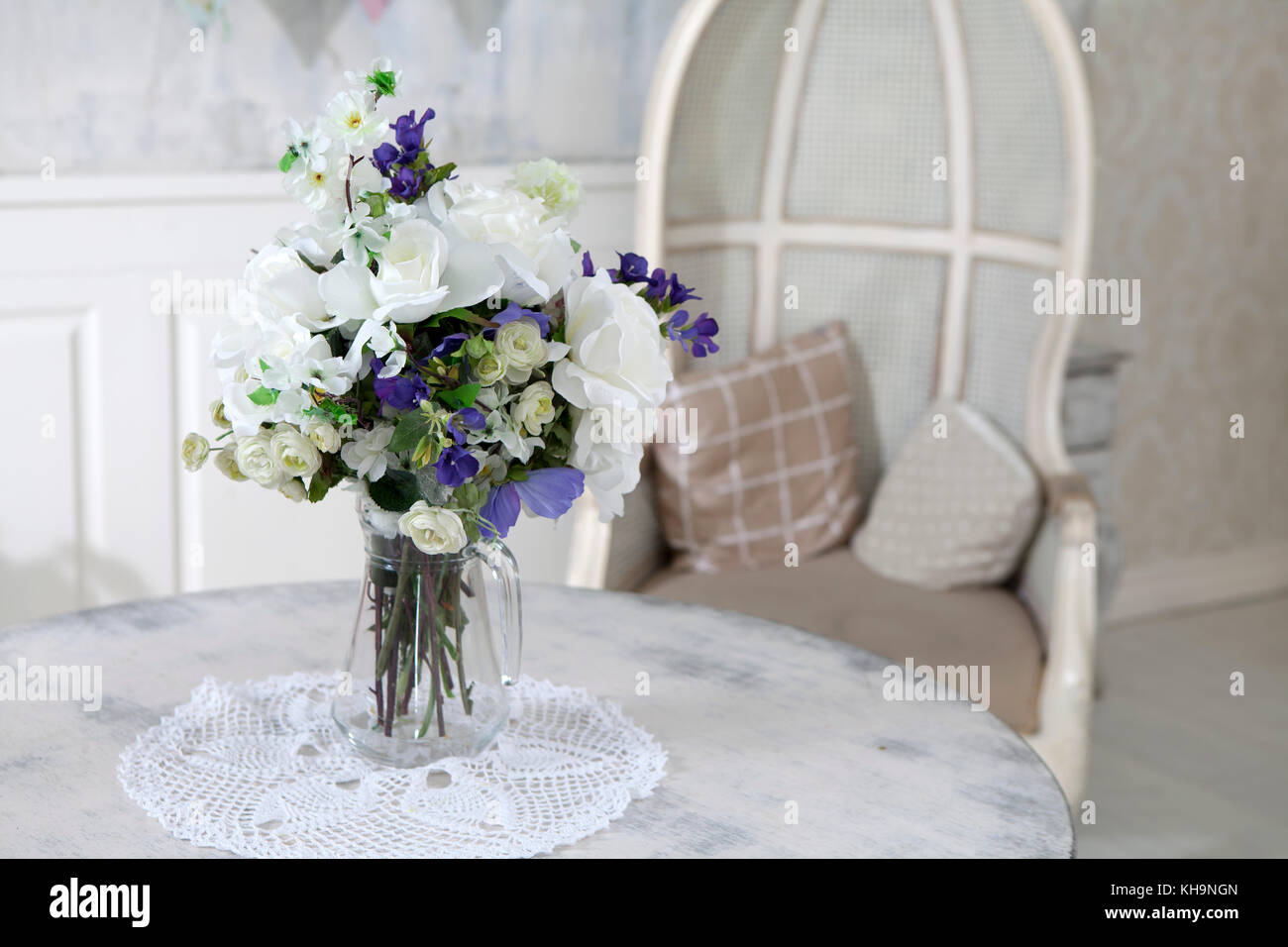 Bouquet of artificial roses, phlox and bells on a table in a vase, as an interior decoration Stock Photo