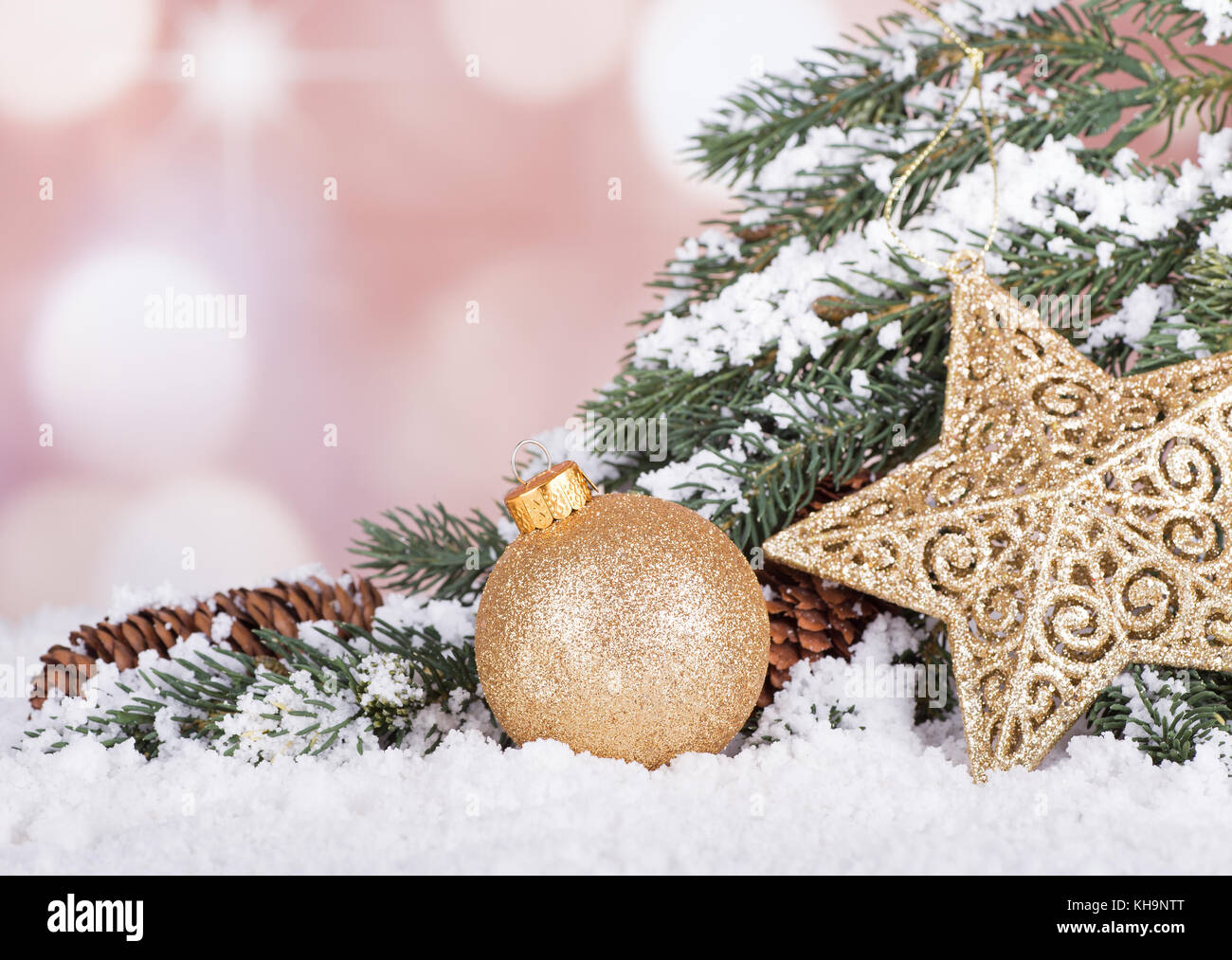 Gold Christmas ball and star with evergreen tree branch in snow Stock ...