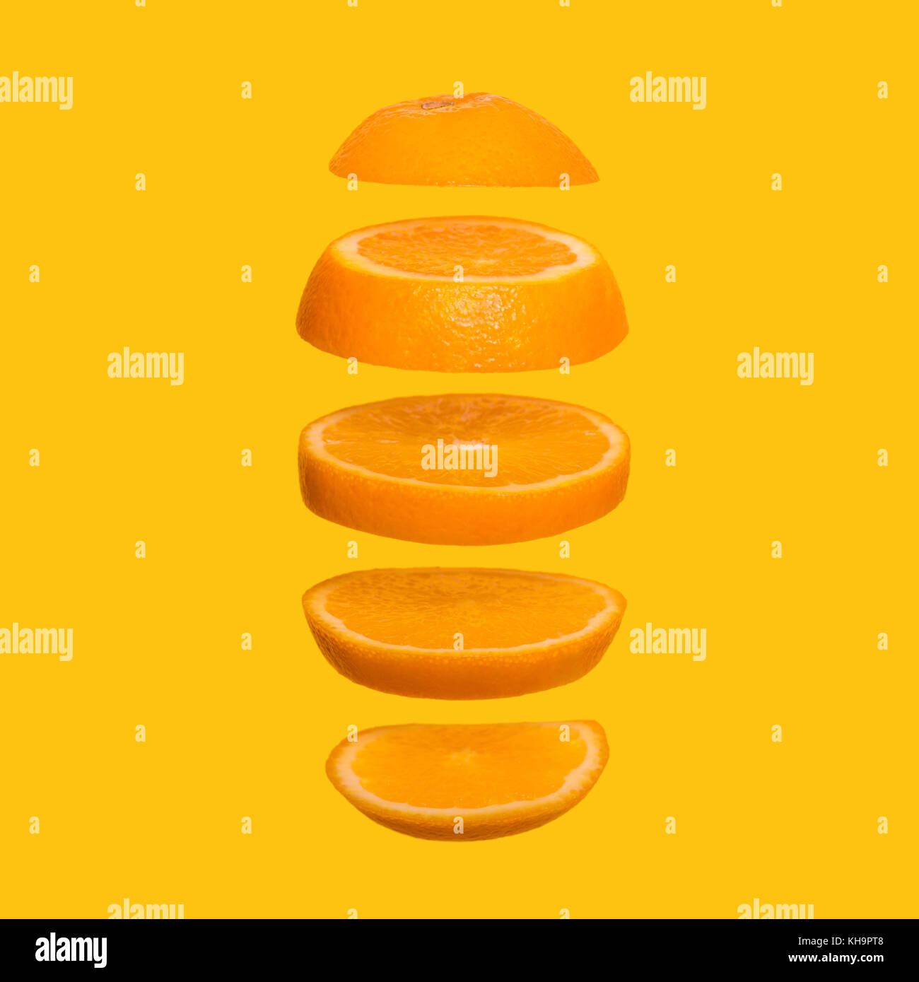 Creative concept with flying orange. Sliced orange on yellow background. Levity fruit floating in the air Stock Photo