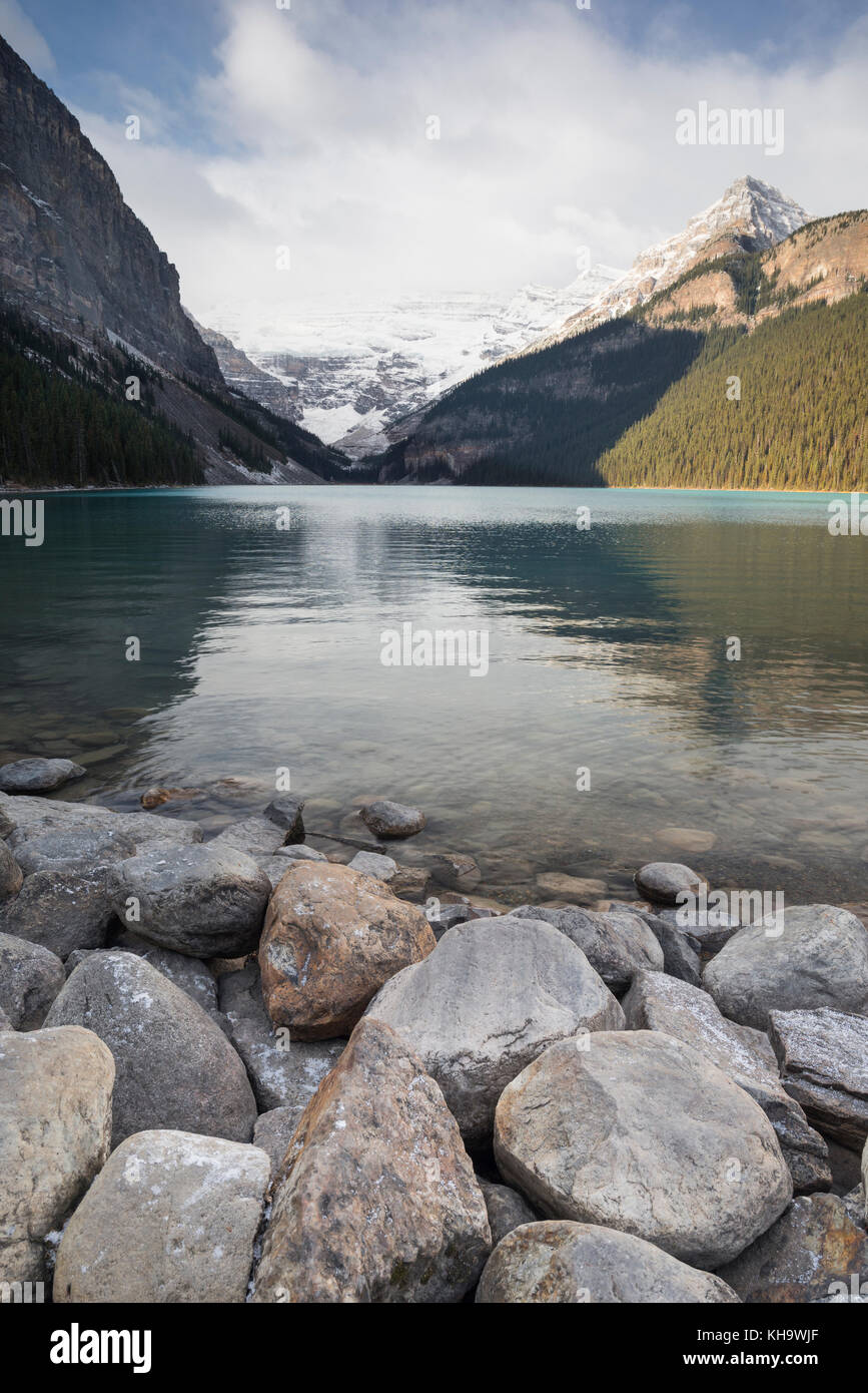 Lake Louise with rocks in the foreground and snowy mountains, Banff ...