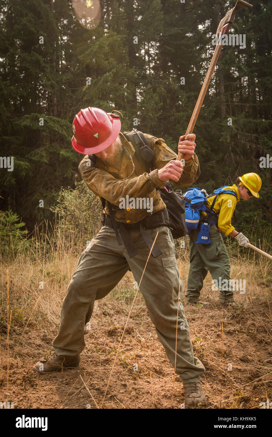 Zane Willert, a firefighter with the Devil's Canyon Handcrew, demonstrates how to dig a handline while supervising tactical training with the Soldiers assigned to 23rd Brigade Engineer Battalion, 1-2 Stryker Brigade Combat Team, Umpqua North Complex, Oregon, Sept. 8. When not fighting the flames during wildfire season, Willert is a cattle rancher in Wyoming. (U.S. Army photo by Pvt. Adeline Witherspoon, 20th Public Affairs Detachment) Stock Photo