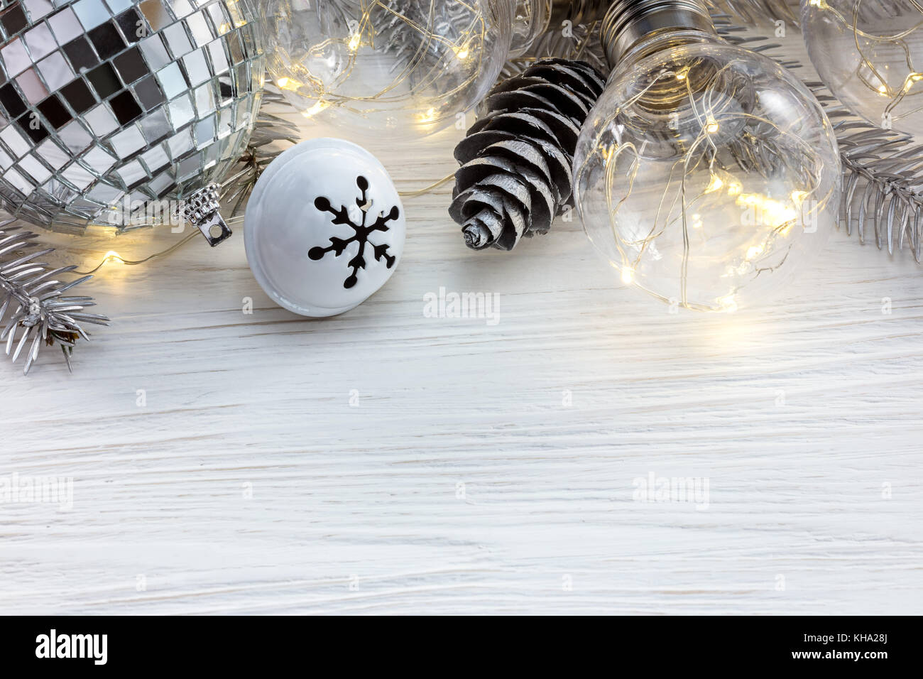 silver christmas tree branch with decorations and retro lamps on white ...