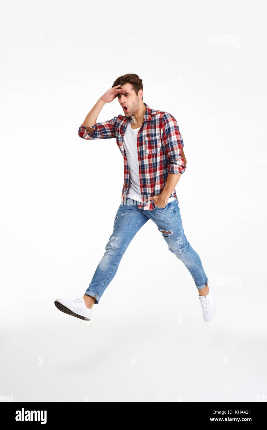 Full length portrait of a young funny man walking while jumping
