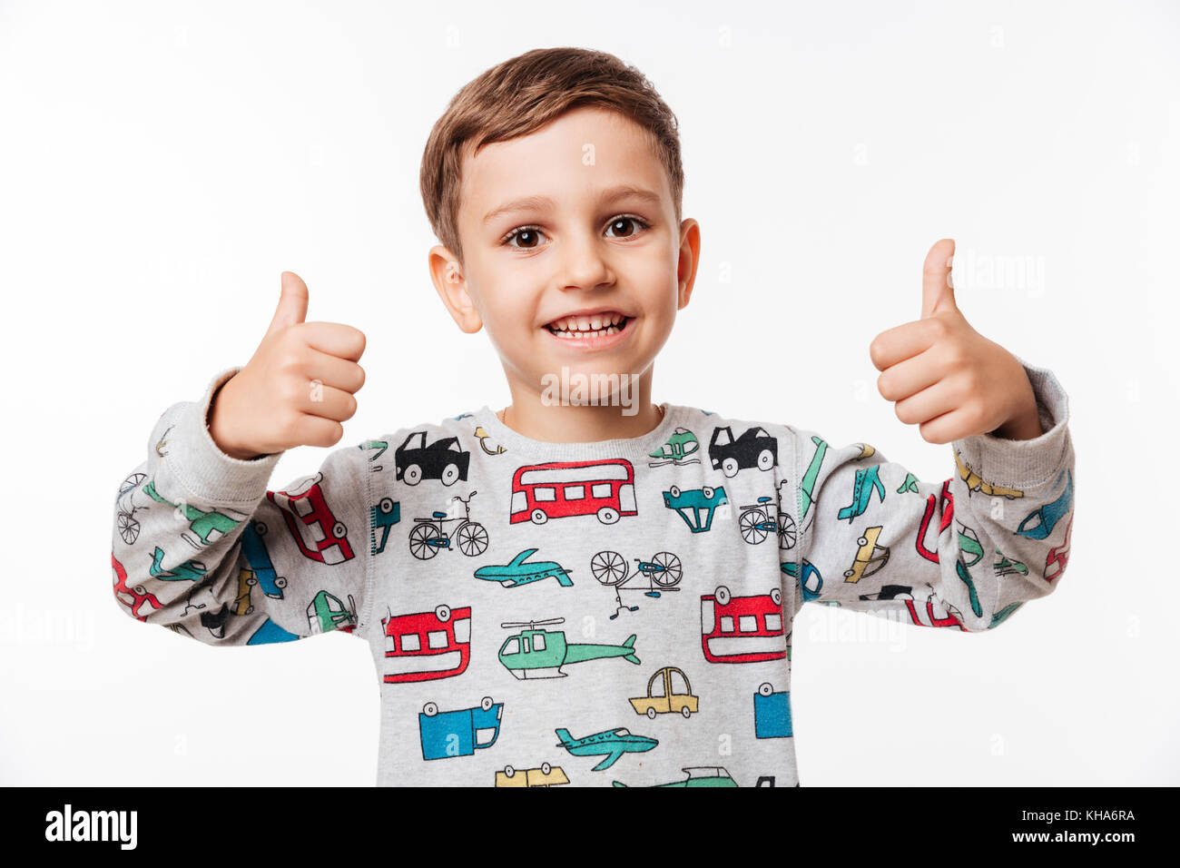 Portrait of a smiling little kid standing and showing thumbs up with ...