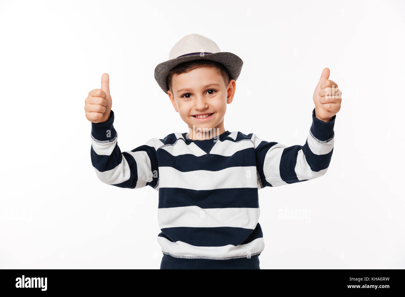Portrait of a cheerful cute little kid in a hat showing thumbs up ...