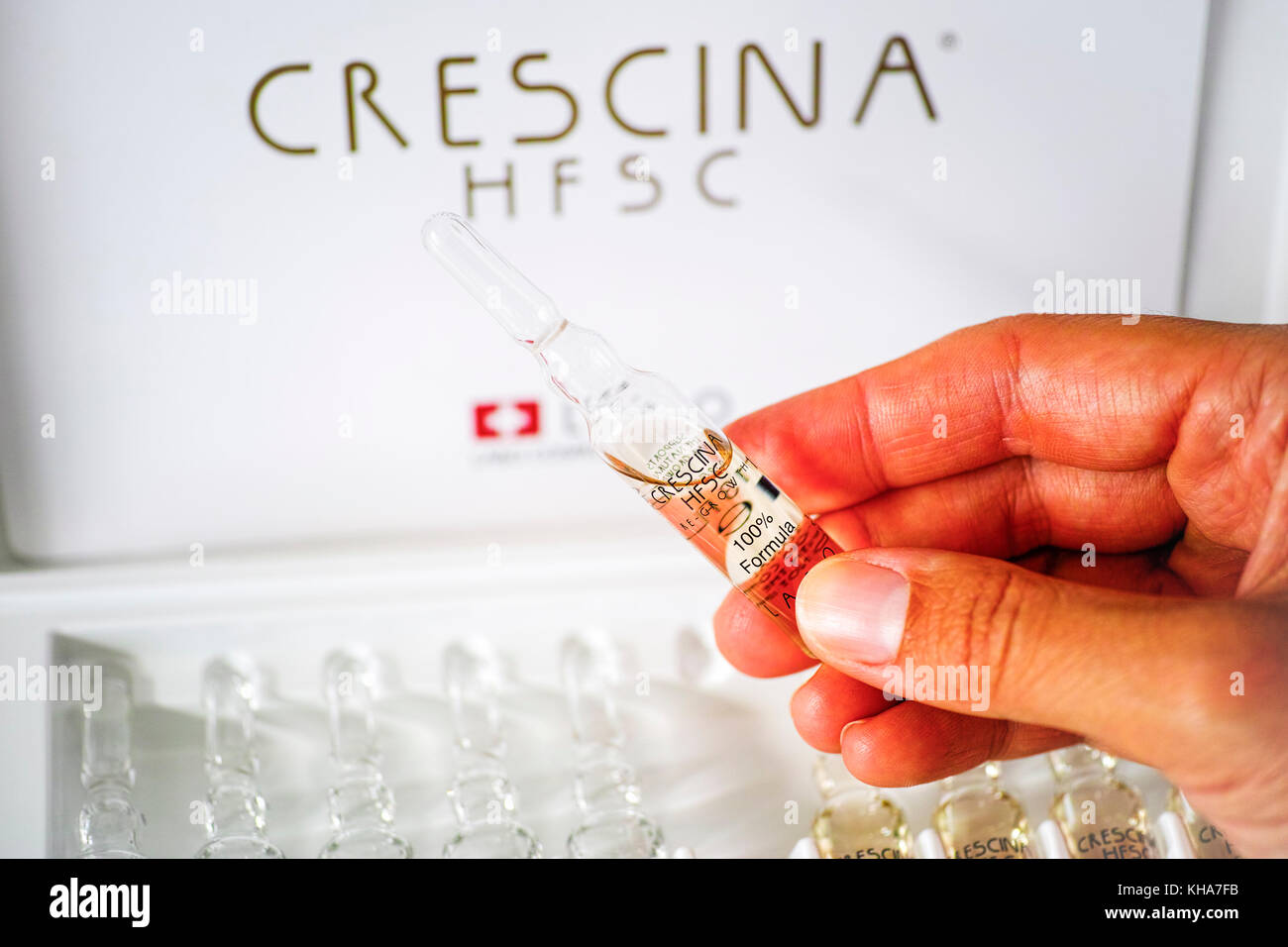 Paphos, Cyprus - November 13, 2015 Woman hand with ampoule of Crescina HFSC  Re-Growth formula in front of Crescina treatment box. Crescina HFSC preser  Stock Photo - Alamy