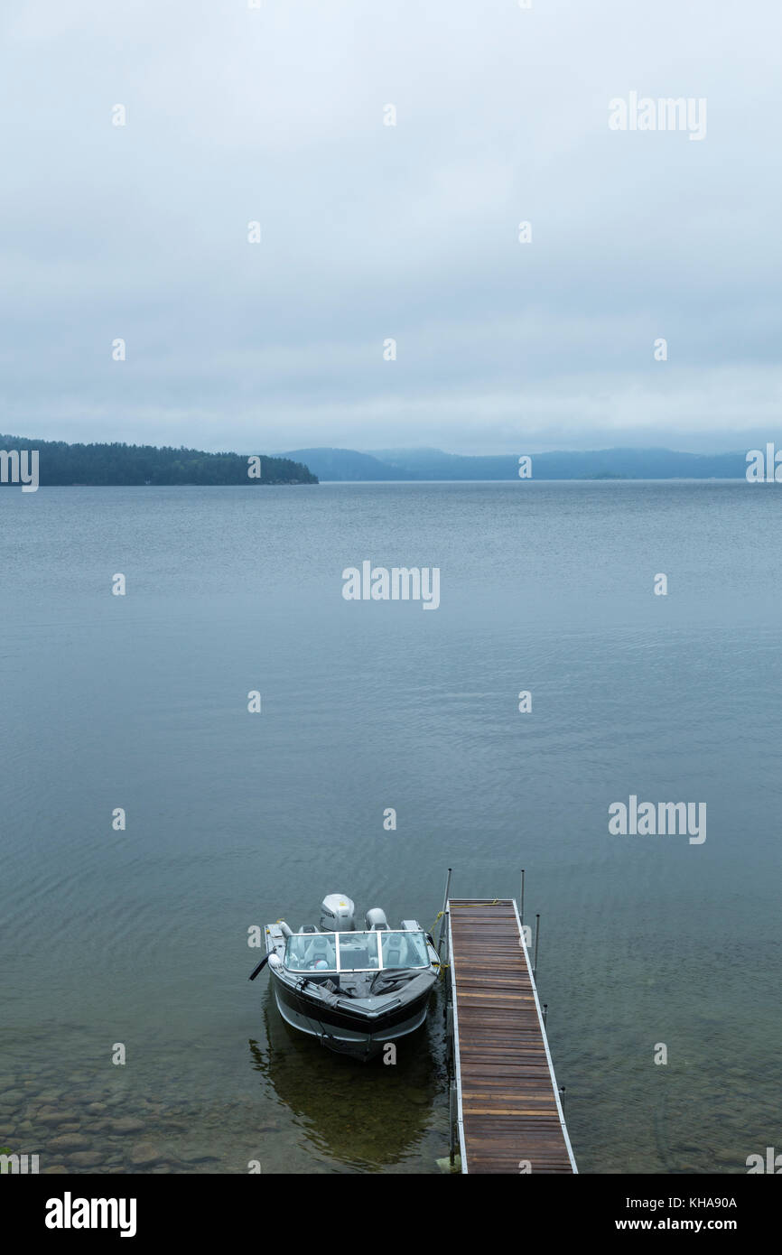 Boat at dock on rainy day, Lake Matinenda, Algoma District, Ontario