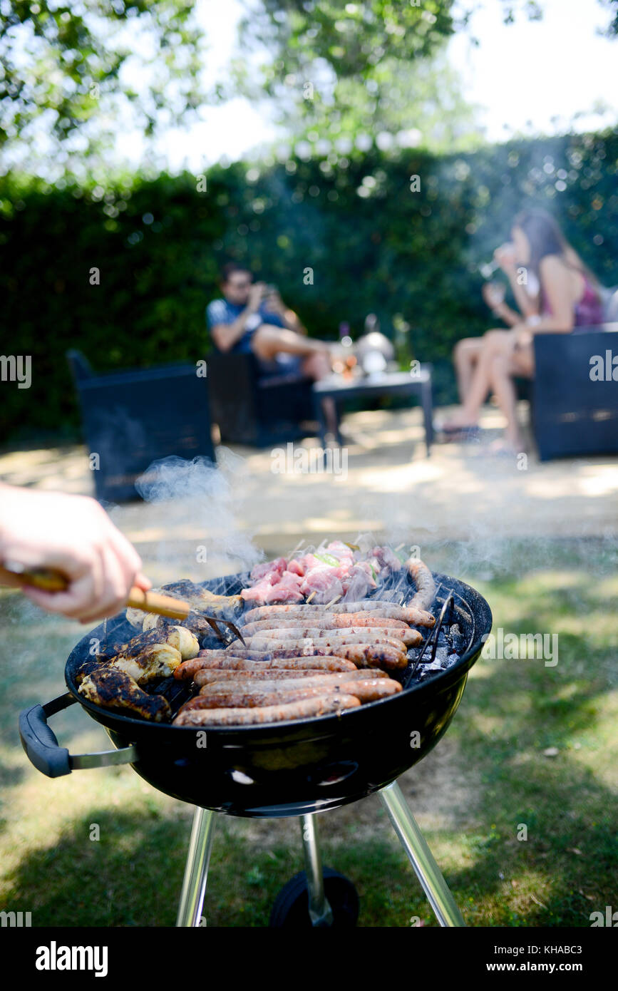Close up of a barbecue grill with meat and sausages cooking during a ...