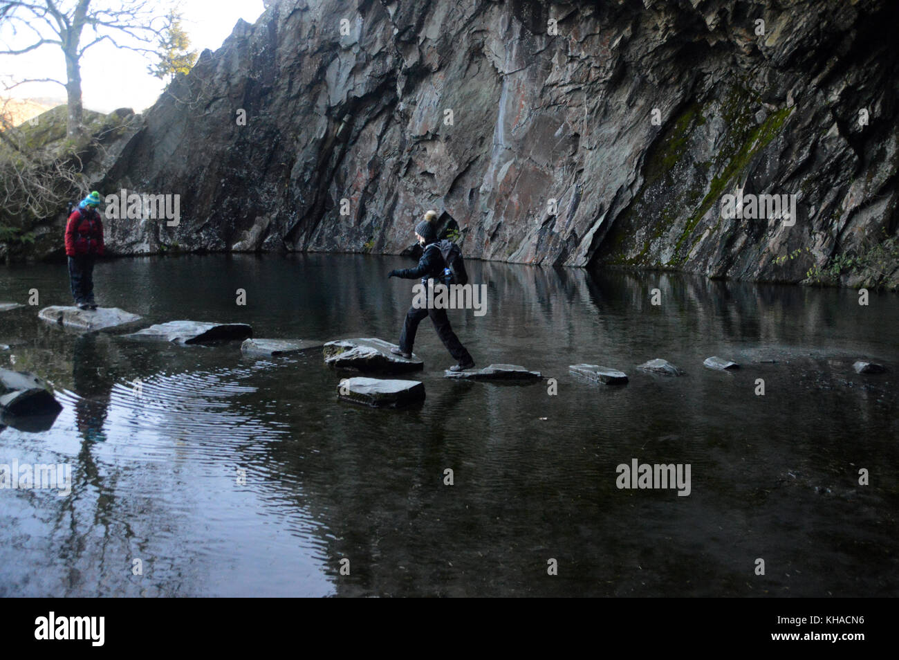 Two Women Fell Walkers in Rydal Cave Walking on Stepping Stones above