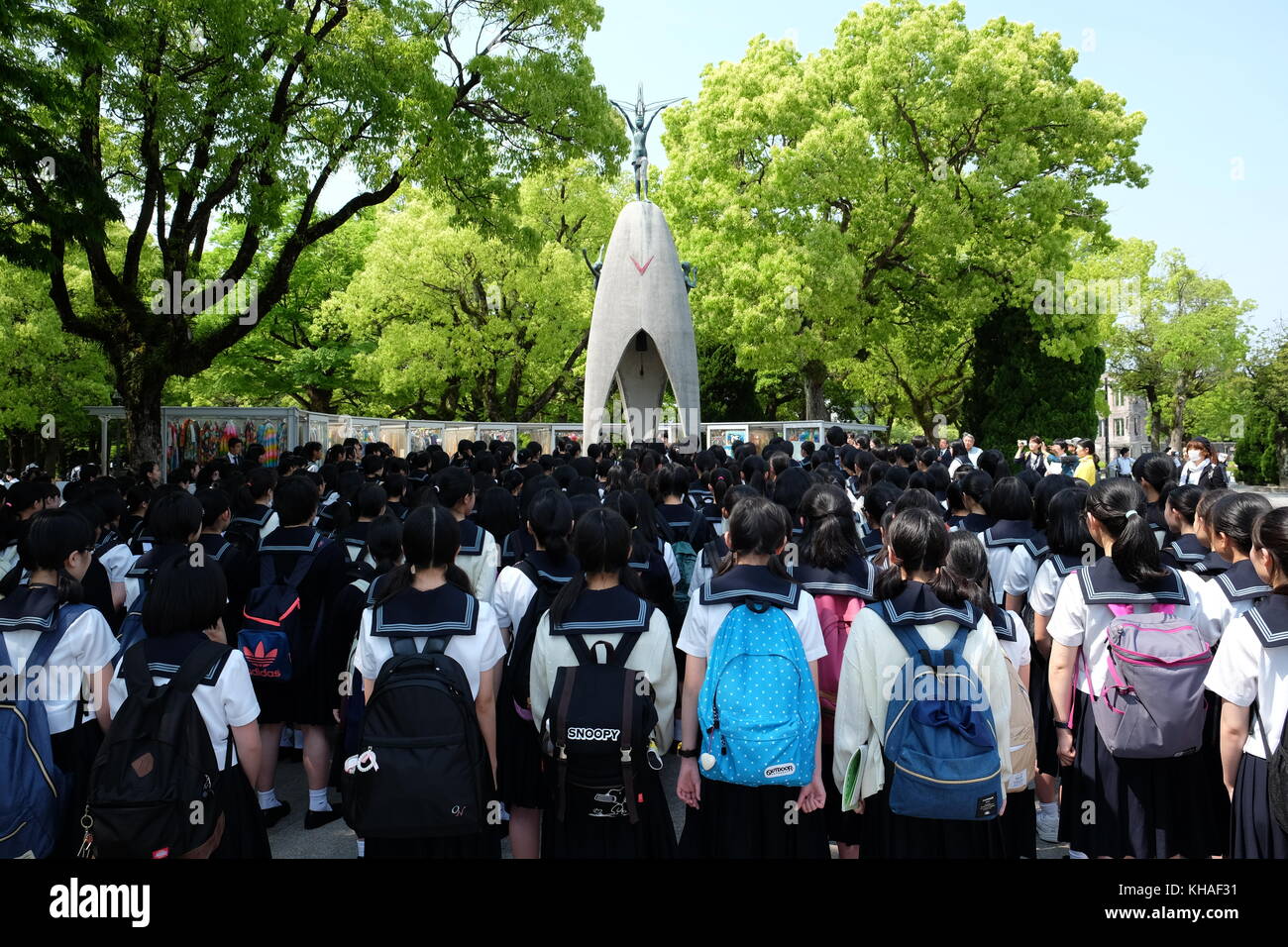 Japanese school children in uniform singing in front of the Children's Peace Monument in Hiroshima, Japan. Stock Photo