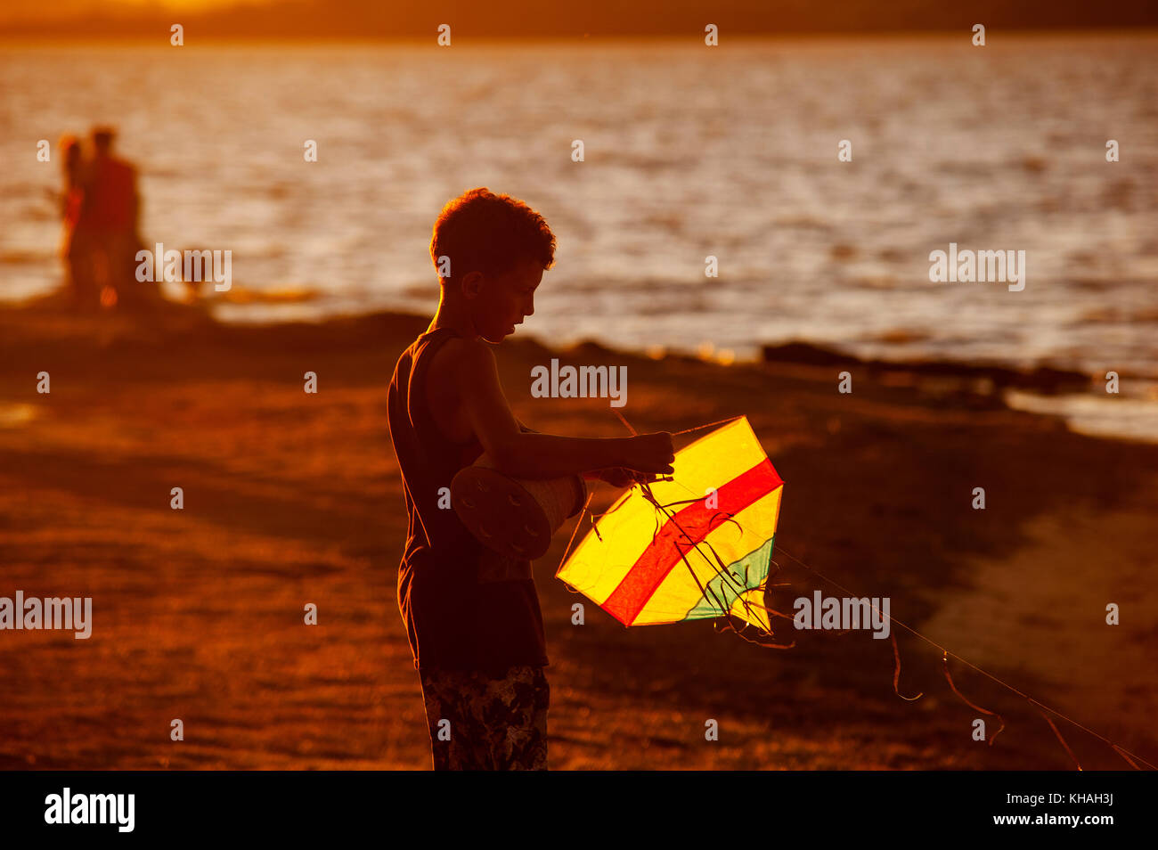Boy with his kite at sunset, Maricá Lagoon, Maricá, Rio de Janeiro, Brazil Stock Photo