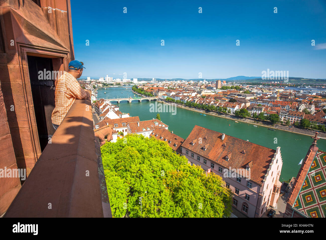 Young attractive man enjoying the view to old city center of Basel from Munster cathedral, Switzerland, Europe. Stock Photo