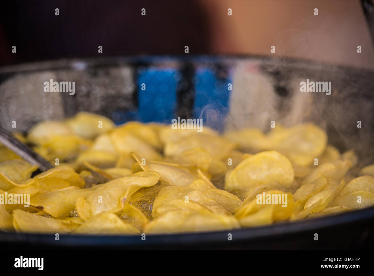 Sliced potatos been fried in a large olive oil pan Stock Photo Alamy