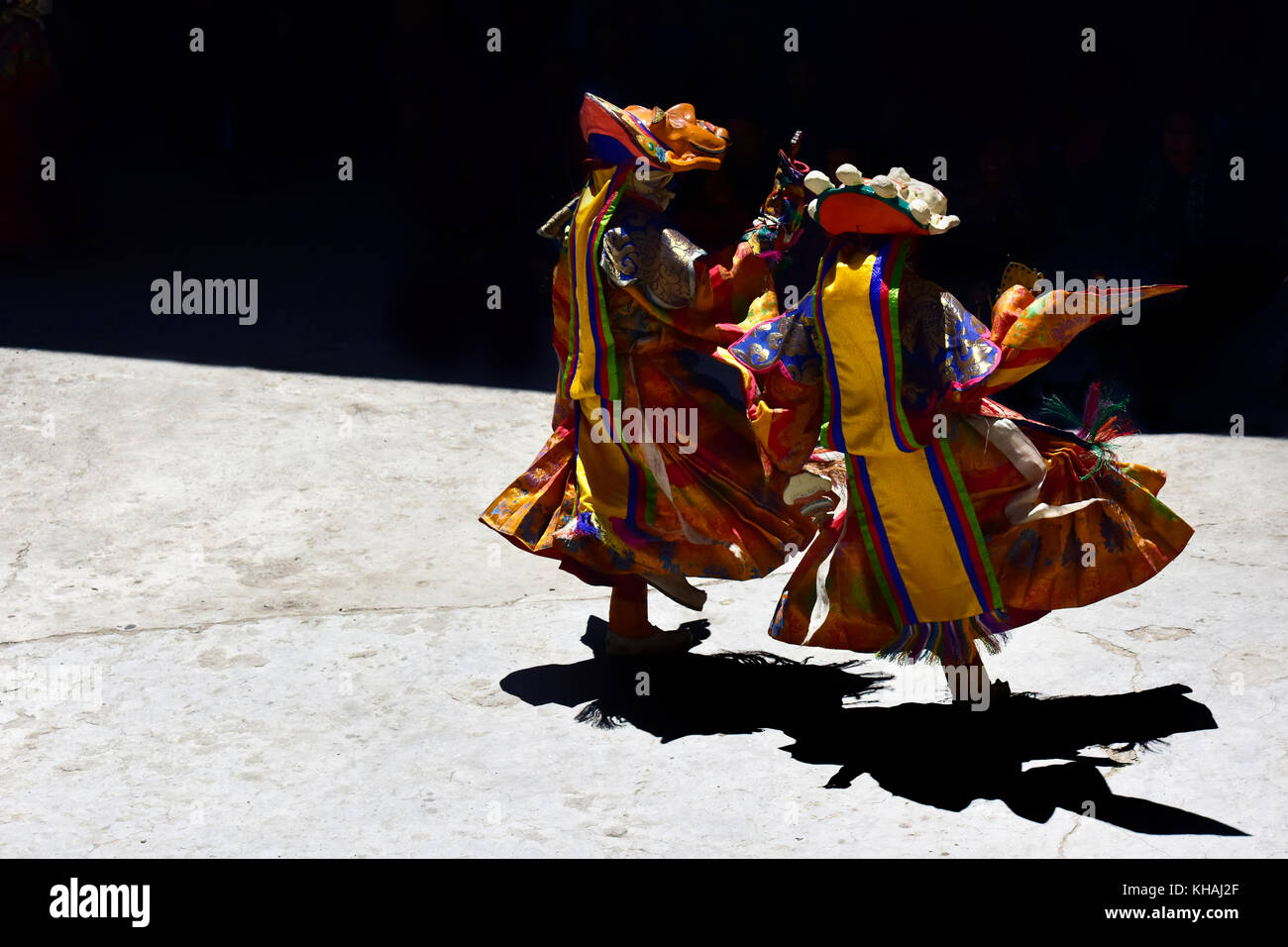 Buddhist lamas dance in sacred Tibetan clothes and masks on the court yard of the monastery, the Himalayas, Northern India Stock Photo