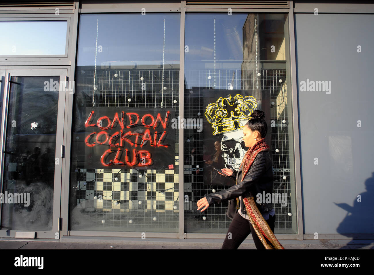 Woman walks past London Cocktail Club in Shoreditch, London, England