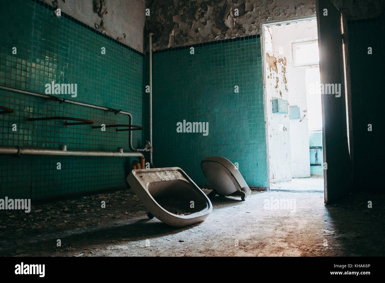 Two hand basins lie detached from the wall inside an abandoned building in Chernobyl, Ukraine Stock Photo