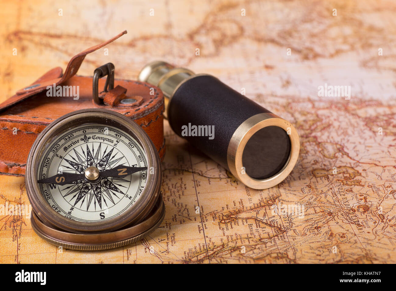 Brass compass and telescope on a world map Stock Photo