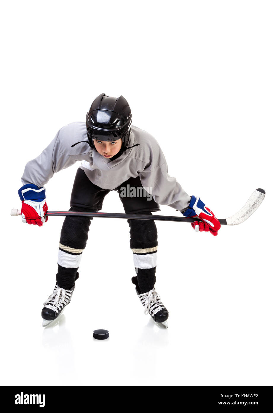 Junior ice hockey player with full equipment and uniform isolated on
