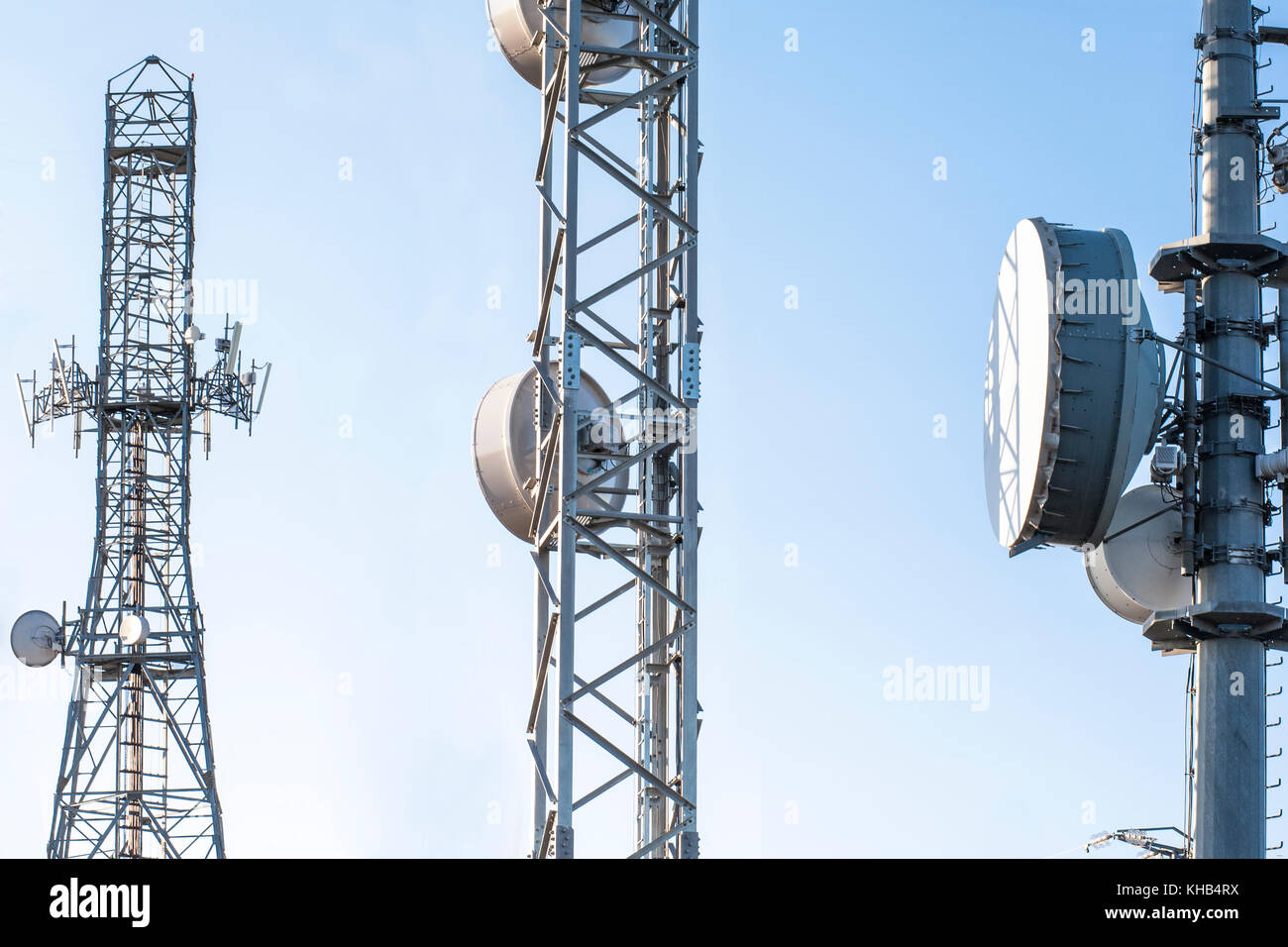 Broadcast relay station antennas at rising. Telecommunications towers with blue clear sky. Stock Photo